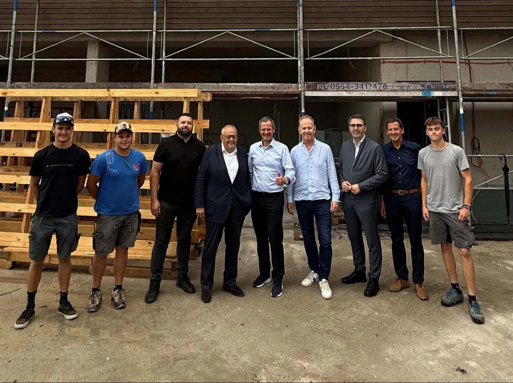 Rohbaufest des Projekts ‚Wohnen & Arbeiten am Berglift‘ in Hopfgarten – Mitarbeitende, Projektpartner und Vertreter der Pletzer Gruppe feiern gemeinsam vor der Baustelle.